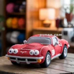 A crocheted red toy car with large eyes and detailed features is placed on a wooden table. The background shows colorful yarn balls and a softly lit room, contributing to a cozy atmosphere.