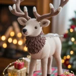 A crocheted reindeer with detailed antlers stands on a table decorated with a red and green plaid runner, surrounded by small wrapped Christmas gifts and string lights.