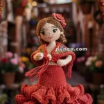 A crocheted flamenco dancer doll wearing a vibrant red dress with ruffled layers, standing on a decorative wooden platform in a colorful alleyway. The doll is adorned with a flower in her hair, and a crocheted banner stating 'OLÉ!' hangs above her.