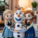 Crocheted dolls resembling characters from a popular animated movie, holding a sign reading 'Arendelle' in colorful letters, placed in a cozy living room setting.