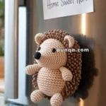 A crocheted hedgehog magnet on a refrigerator door with a note pinned above reading "Home Sweet Home."