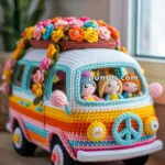 A crocheted model of a colorful hippie van adorned with a peace sign on the front and topped with a garland of vibrant flowers. Inside the van, there are small crocheted figures representing people sitting and looking out the windows.