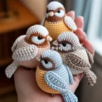 A hand holding four crocheted bird figurines in different shades of beige, brown, and blue, each featuring detailed stitching and expressive eyes.
