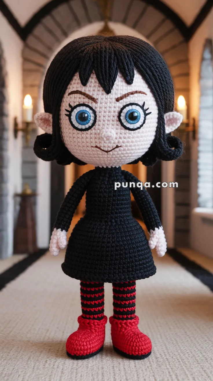 A handmade crochet doll with large blue eyes, black hair, and a black dress, standing in a hallway with arched windows and lit wall sconces. The doll also wears red and black striped stockings and red shoes.