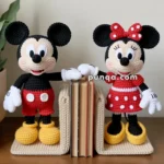 Crocheted Mickey and Minnie Mouse bookends holding books upright on a wooden surface.