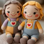 Two handmade crochet dolls sitting on a knitted cushion, each with cheerful facial expressions, colorful clothing, and a heart emblem on their chests.
