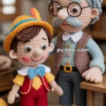 Crocheted figures of an elderly man with glasses and a mustache, and a smiling boy in a yellow hat and red outfit, standing together indoors.