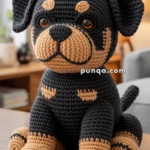 A crocheted stuffed toy of a dog with brown and black yarn, sitting on a wooden table in a cozy living room setting.
