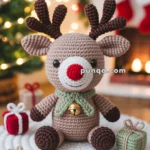 A crocheted reindeer with a red nose and antlers, adorned with a green scarf and bell, seated on a white knitted mat, surrounded by small gift boxes and holiday decorations.