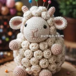 A crocheted sheep pin cushion with colorful pins on its back, sitting on a wooden surface with additional sewing pins around it.