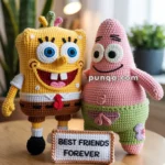 Two crocheted cartoon character dolls stand on a wooden table with a sign reading "Best Friends Forever." The background includes a potted plant and a lamp.