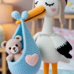 Crocheted stork wearing aviator goggles holding a blue basket with a small crocheted teddy bear inside, set in a cozy nursery room.