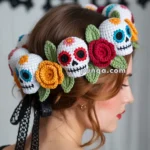 A person wearing a colorful crochet headband adorned with skulls and flowers, with a papercut banner in the background.