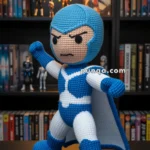 A crochet doll of a superhero in a blue and white costume with a determined expression, standing in a dynamic pose on a table in front of a bookshelf with comic books and action figures.