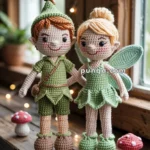 Two hand-knitted dolls resembling fictional characters, Peter Pan and Tinker Bell, stand on a wooden surface decorated with small fabric mushrooms and a "Neverland" sign, with warm string lights and a window in the background.
