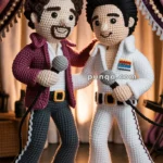 Two crocheted doll figures are posed as musicians with microphones, one in a maroon jacket and grey pants, the other in a white jumpsuit. They stand on a colorful circular mat with a spotlight in the background.