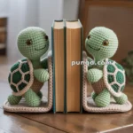 Two crocheted turtle bookends holding up books on a wooden table, with a blurred background showing a window and a woven chair.
