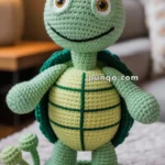 A crocheted turtle figurine wearing a yellow crown, with a green shell and a yellow belly, stands on a circular, textured platform with various small knitted discs placed around it.