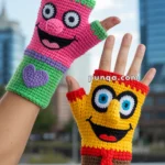 Crocheted fingerless gloves with colorful cartoon character faces; one glove is pink and green with a heart, the other is yellow and brown with red and black details.