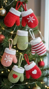 Crocheted mitten ornaments in various colors and patterns hang on a Christmas tree.