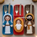 Three crocheted cutlery holders featuring nativity figures: one with a blue background depicting Mary, one with a red background depicting baby Jesus, and one with a brown background depicting Joseph, surrounded by Christmas decor with candles and lights.